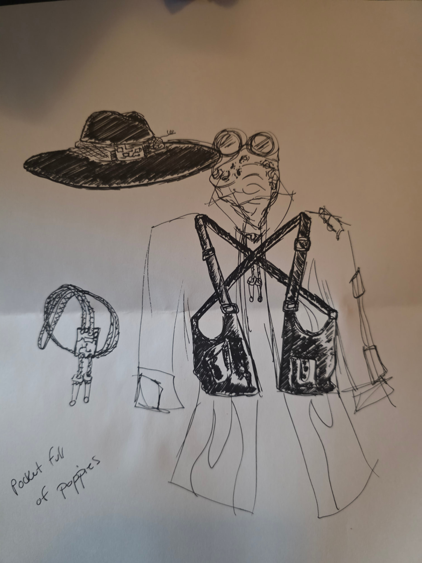 Early pen sketch of The Traveler: wide-brimmed hat, goggles, long coat with crossed leather satchel straps, a bolo tie, and the handwritten note "Pocket full of poppies"